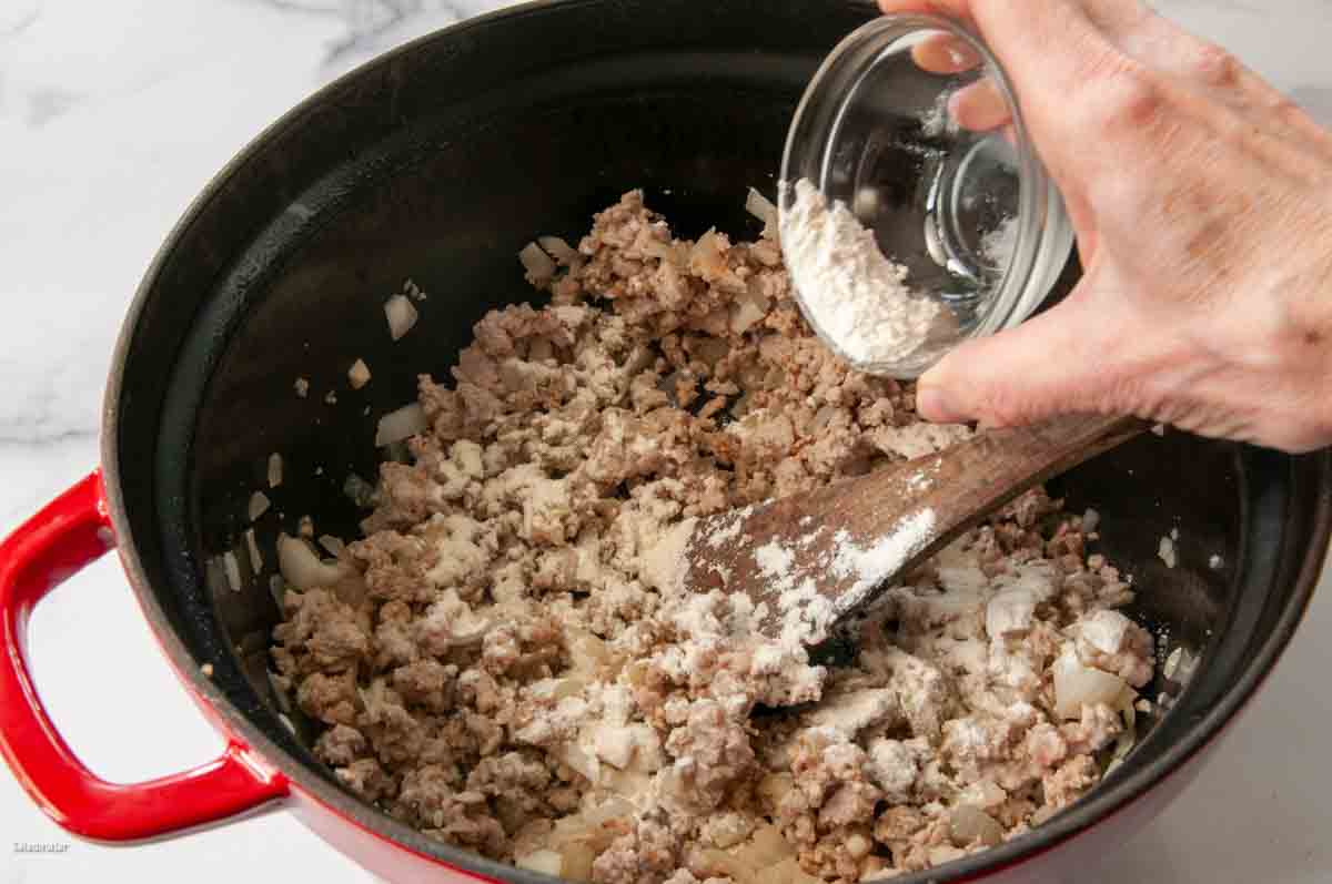 Adding flour to the ground pork and vegetables