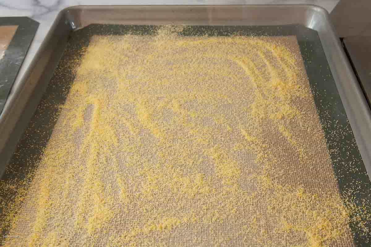 baking sheet prepared with a silicone mat sprinkled with cornmeal.