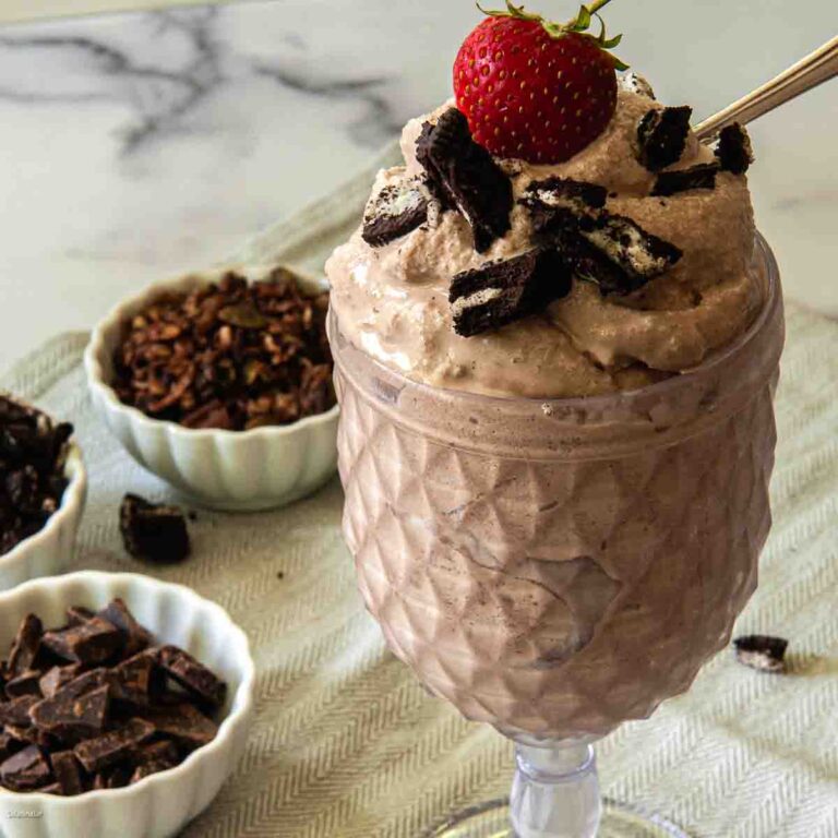 yogurt creami with oreo pieces and a strawberry on top.