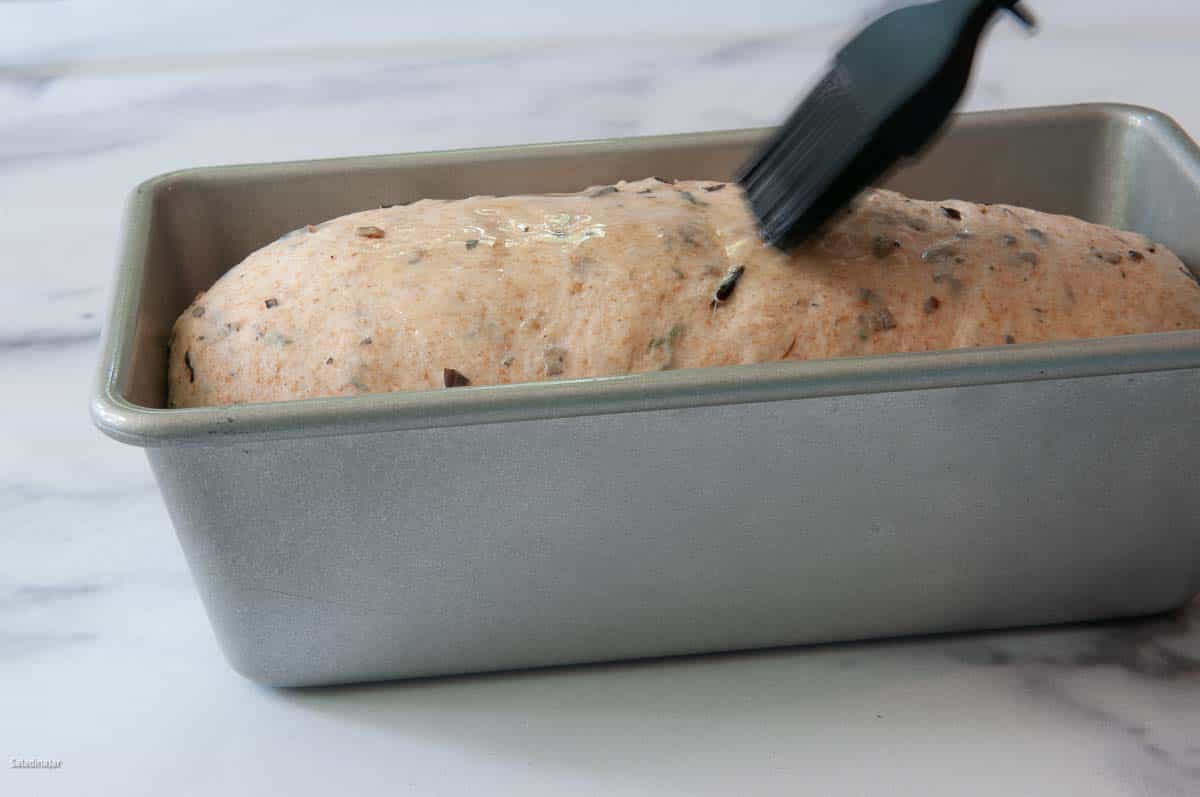 Brushing the dough with butter.