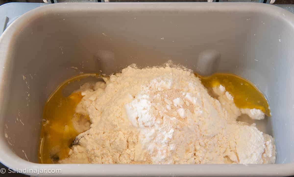 Loading bread machine pan with all ingredients.