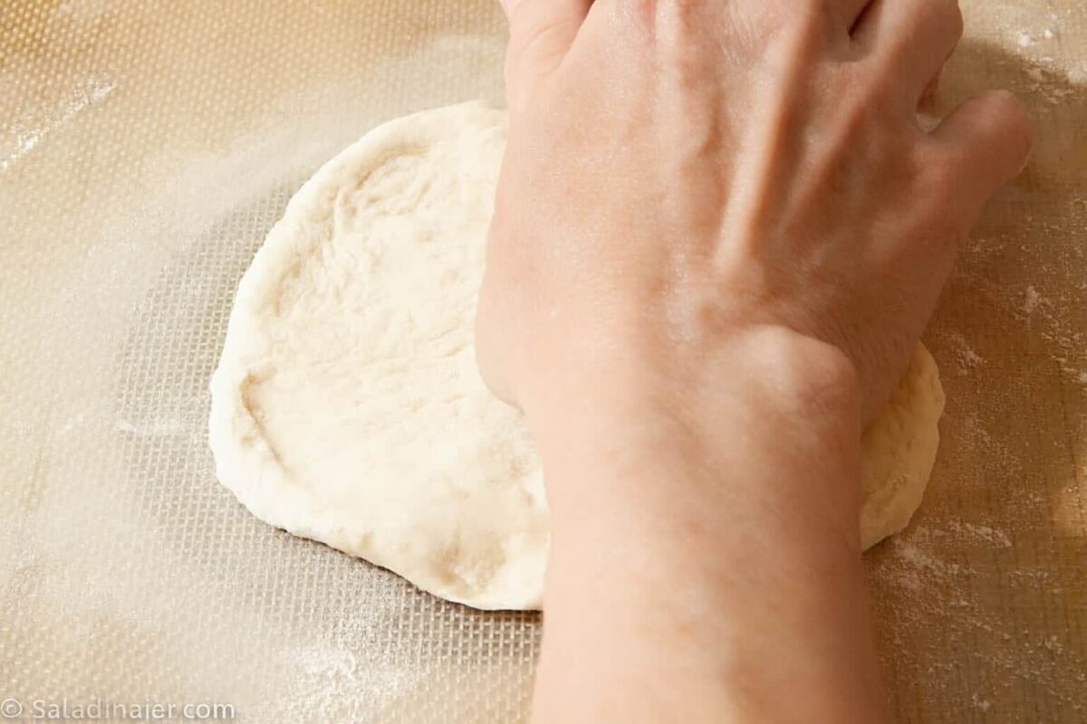 using the palm of my hand to flatten dough ball.